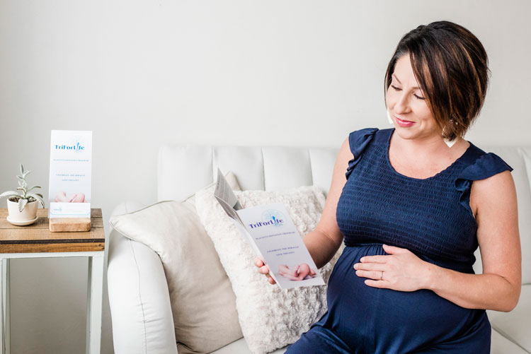 pregnant mother holding a birth tissue recovery brochure